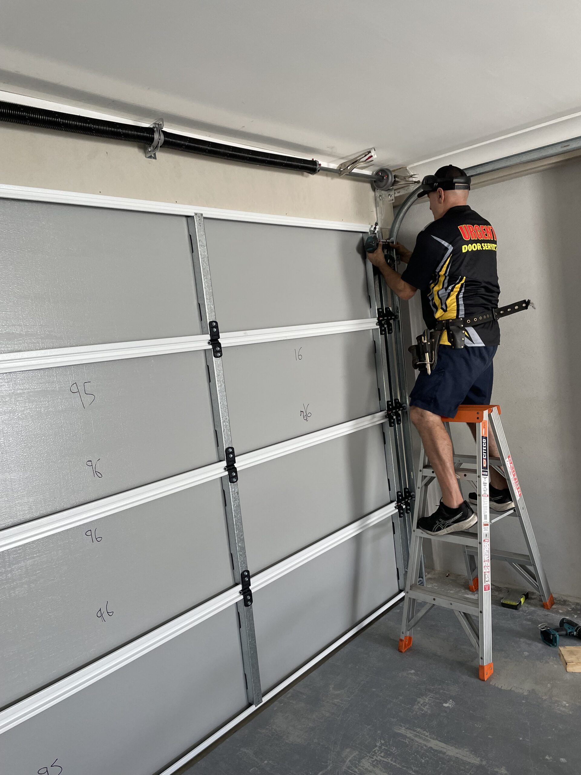 garage-door-maintenance Technician working on a garage door for homeowners across Brisbane, Logan, Ipswich, Redlands, Moreton Bay and the Gold Coast